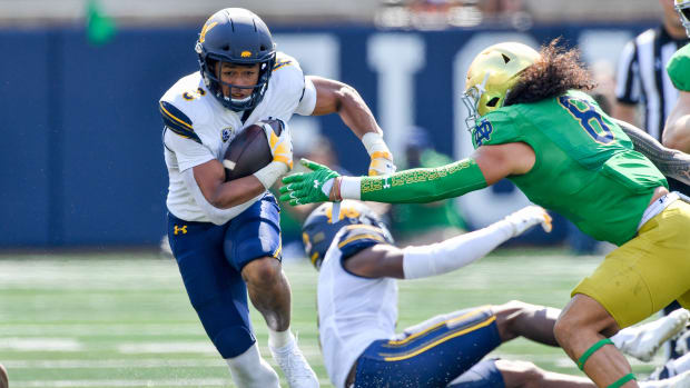 Sep 17, 2022; South Bend, Indiana, USA; California Bears running back Jadyn Ott (6) carries the ball as Notre Dame Fighting Irish linebacker Marist Liufau (8) attempts to tackle in the first quarter at Notre Dame Stadium. Mandatory Credit: Matt Cashore-USA TODAY Sports  